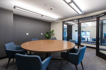 a meeting room with a large wooden table and blue chairs